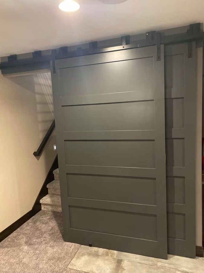 Custom sliding barn door on exposed hardware at a stair landing