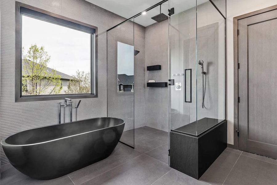 Primary bathroom with freestanding soaking tub and frameless glass shower