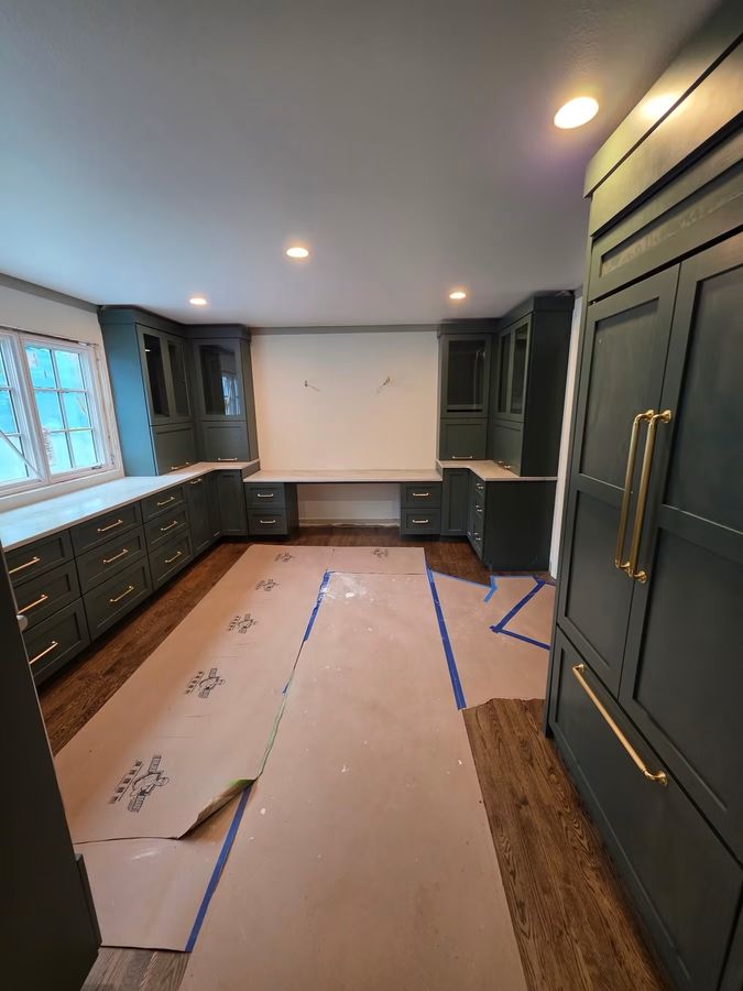 Kitchen remodel in progress with panel-front appliances and a built-in desk