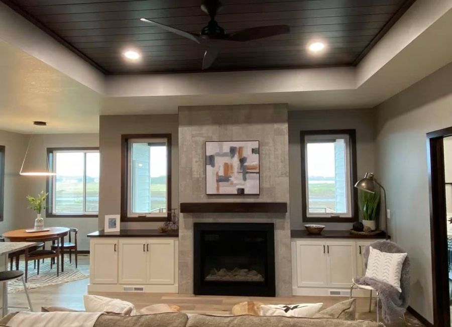 Living room with tile fireplace surround, tray ceiling and shiplap detail