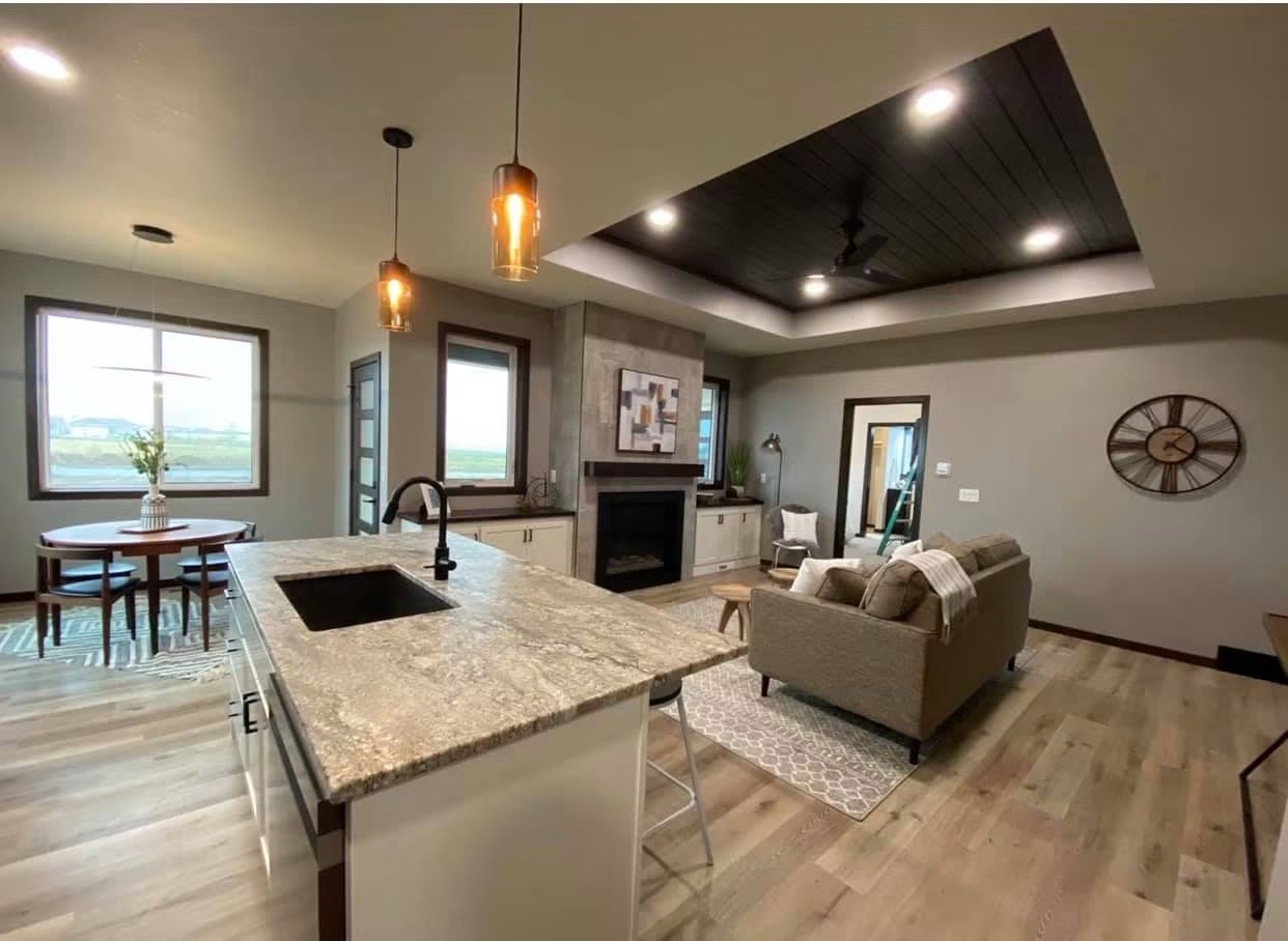 Open concept kitchen and living area with granite island seating