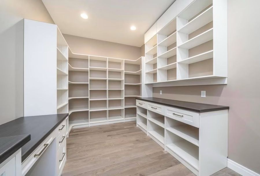 Walk-in pantry with floor to ceiling custom shelving and prep counter