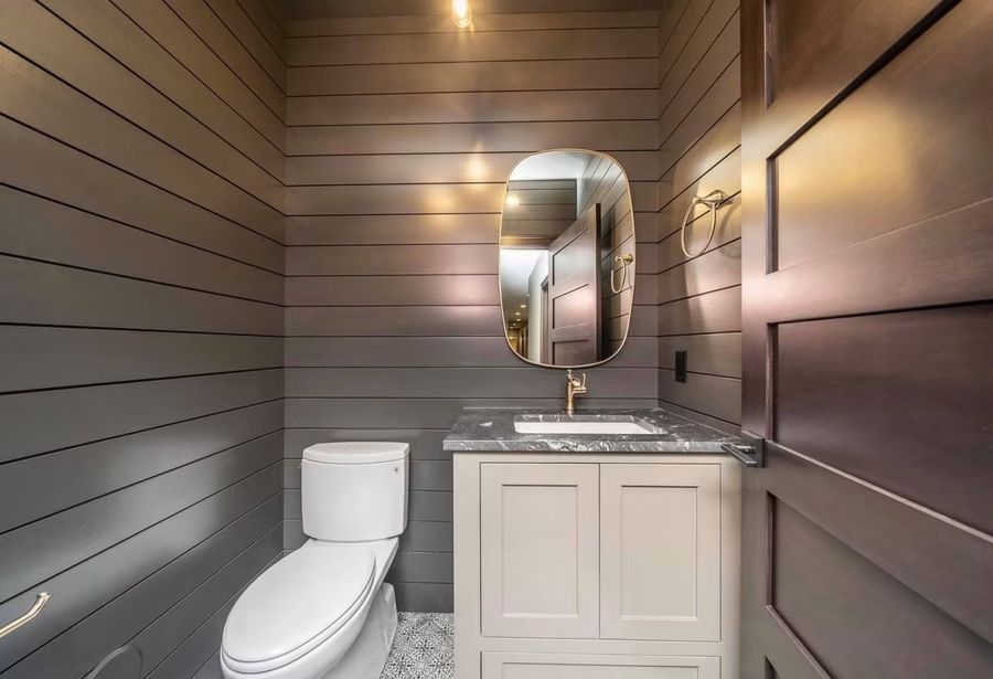 Powder bath with horizontal shiplap walls and stone-top vanity