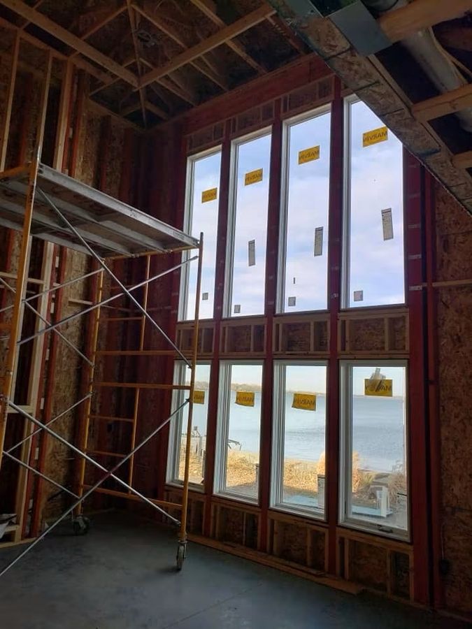 Two-story window wall framed and glazed with scaffolding still in place